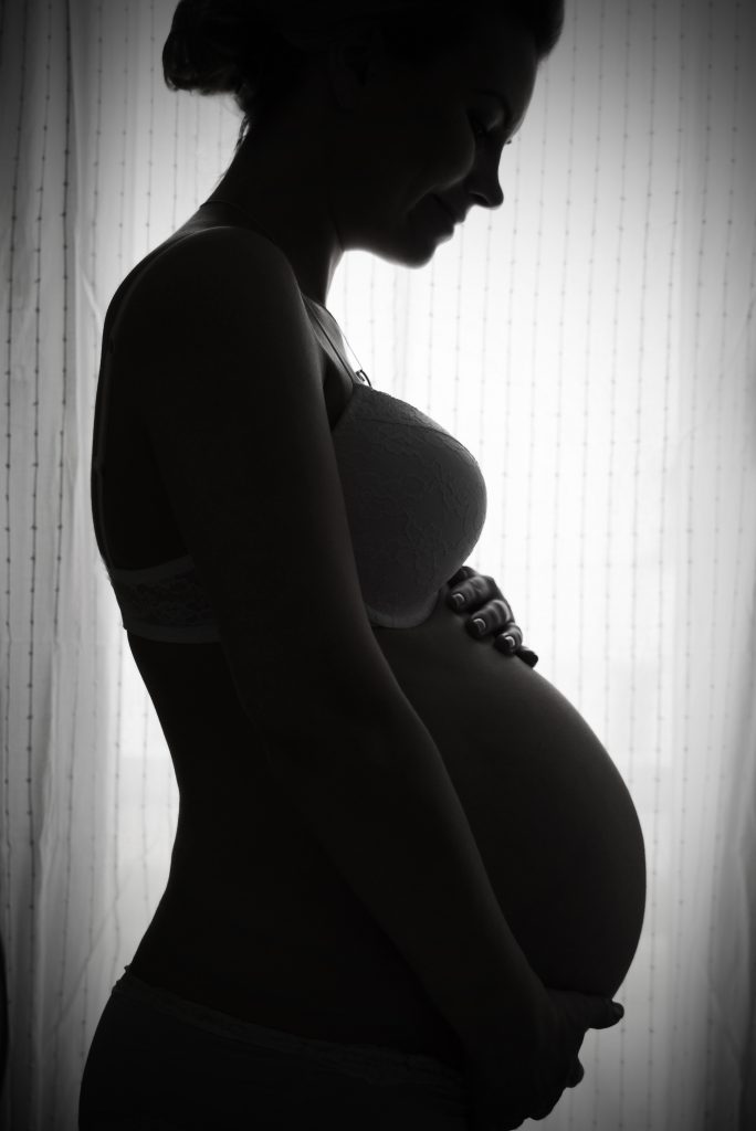 Pregnant woman resting her hands on her bump